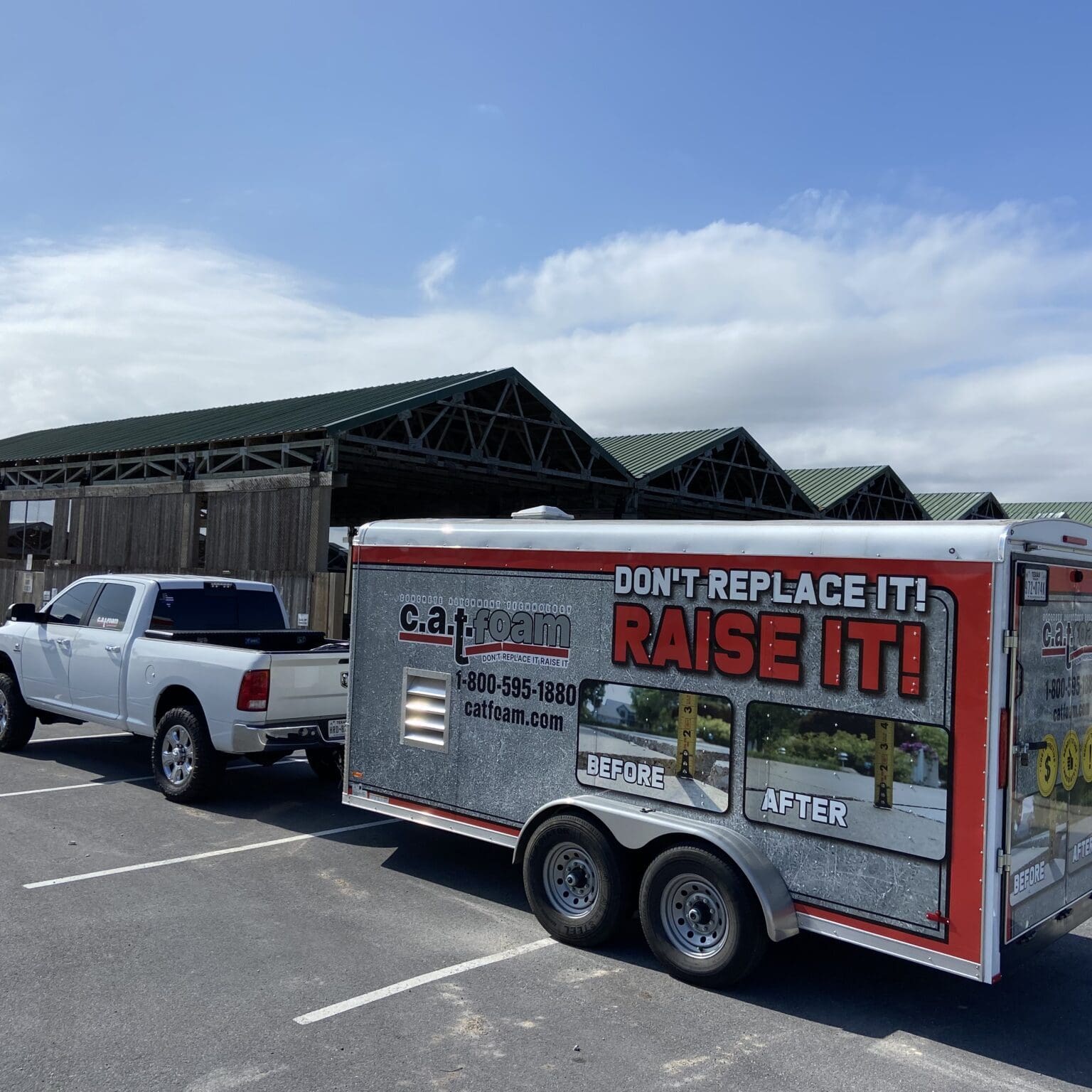 Truck towing trailer near waterfront buildings.